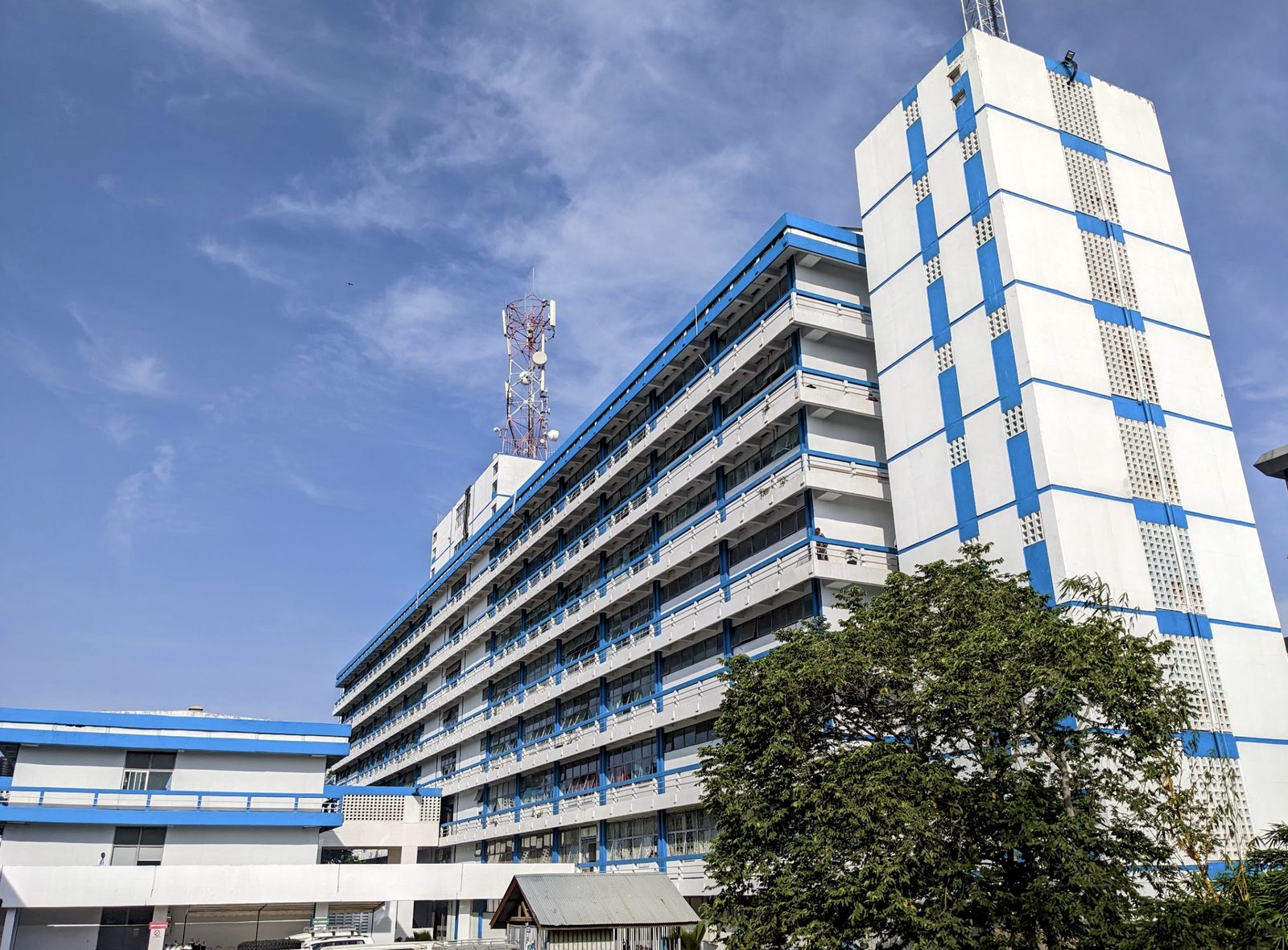 The blue and white main building of Bugando Medical Centre in Mwanza under a clear sky