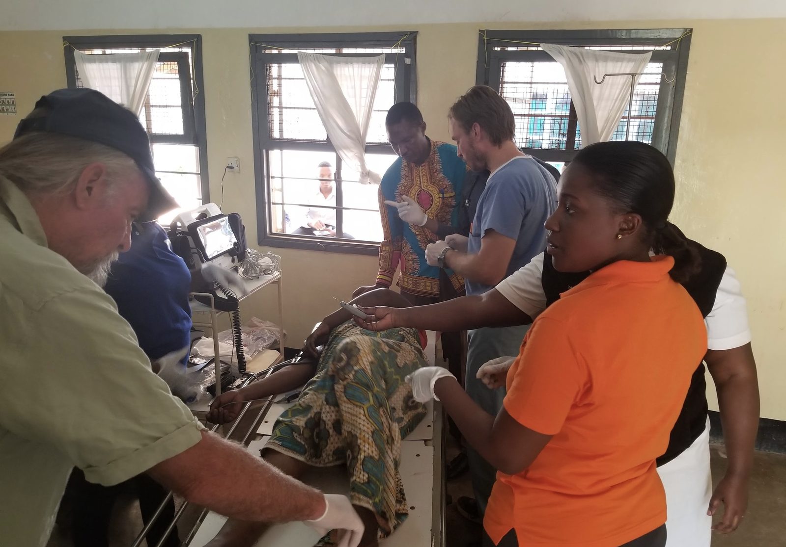 Tanzanian nurses and doctors working with visiting physicians to resuscitate a patient